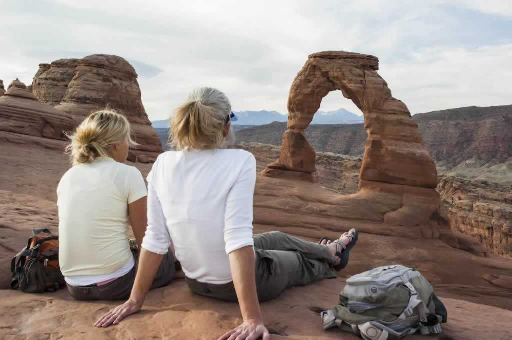 Hikers resting at Delicate Arch, Arches National Park in Utah